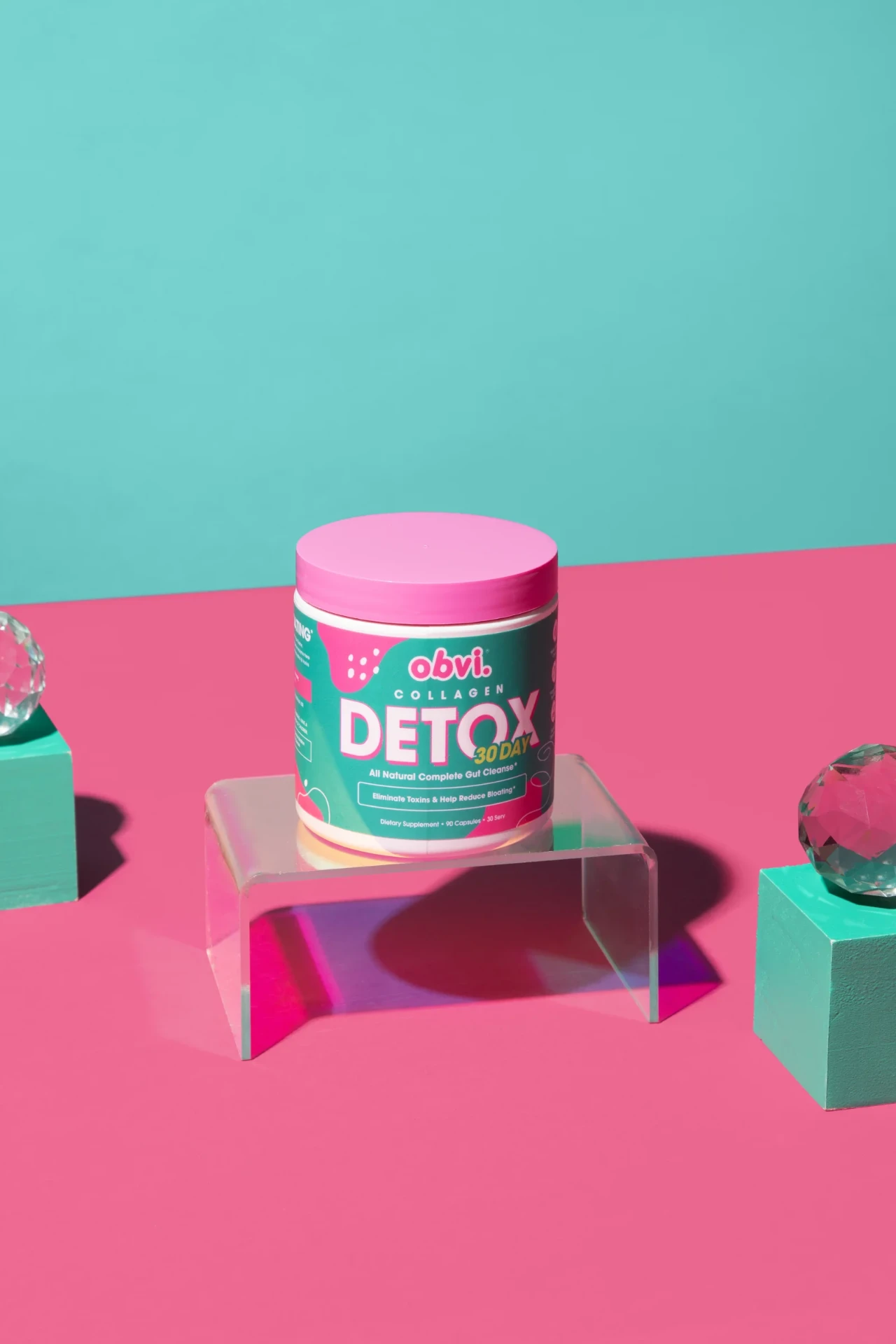 Obvi Collagen Detox jar displayed on a pink and teal pedestal.